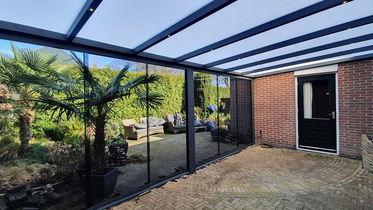 Aluminium veranda met glasdak op een beschutte binnenplaats